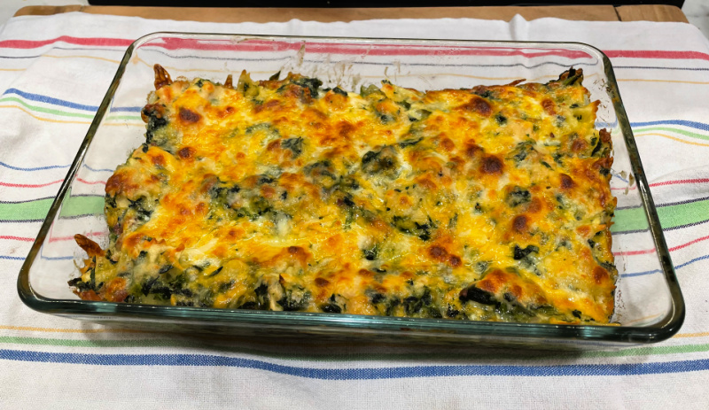 Chicken and Spinach Pasta Casserole is topped with a layer of cheese.
