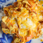 This Cheesy Mexican Chicken is a family-pleasing dinner option with corn chips and cheese on top and served on a bed of rice.