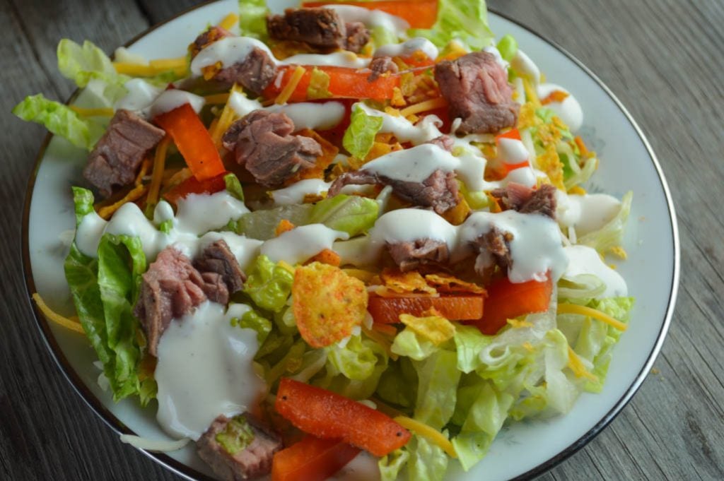 By adding taco seasoning to both the marinade and the dressing, this Flank Steak Salad is a family-pleasing meal with simple additions like Doritos.