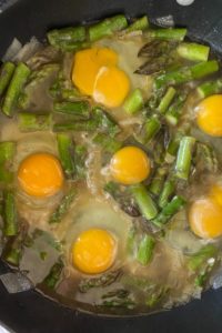 Baked Eggs and Asparagus with Parmesan cheese is an economical meal option for breakfast, lunch or brunch.  Made in a large skillet, this old fashioned asparagus meal is quick and easy. Simply adjust the cooking time to get eggs cooked to your liking.