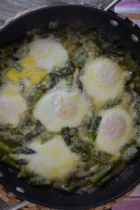 Baked Eggs and Asparagus with Parmesan cheese is an economical meal option for breakfast, lunch or brunch.  Made in a large skillet, this old fashioned asparagus meal is quick and easy. Simply adjust the cooking time to get eggs cooked to your liking.