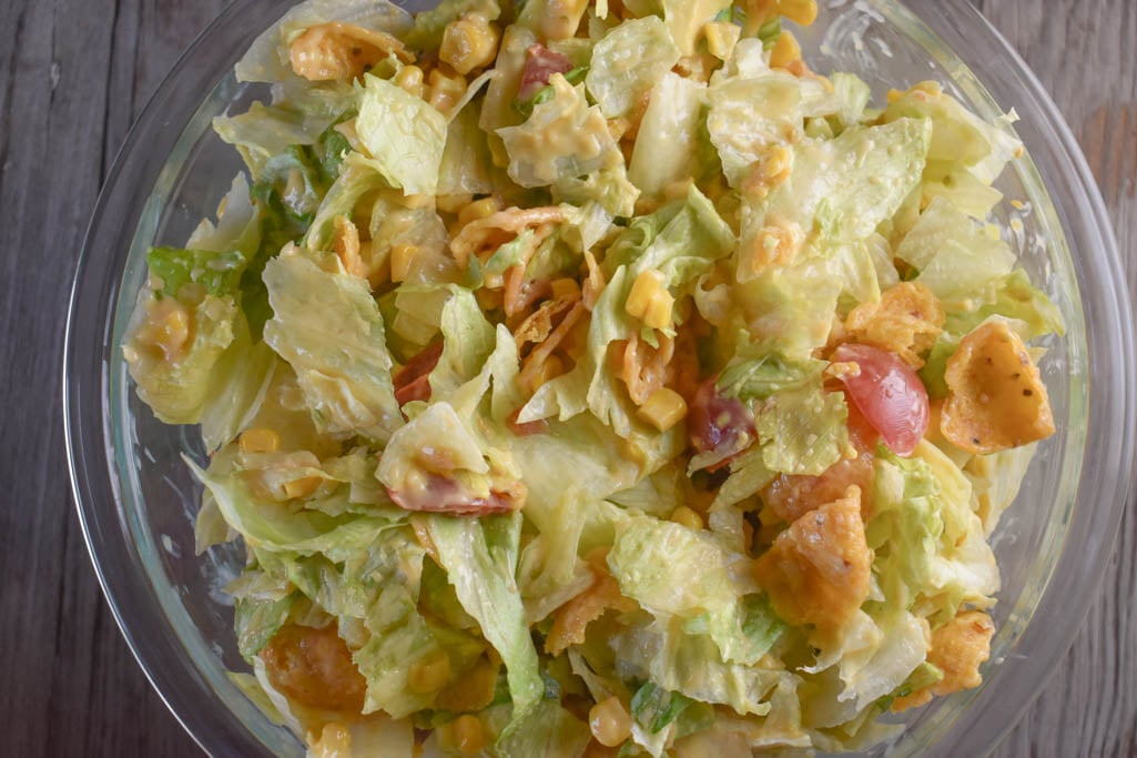 Cheesy Frito Salad is an easy side dish option with corn chips and a melted Velveeta dressing.