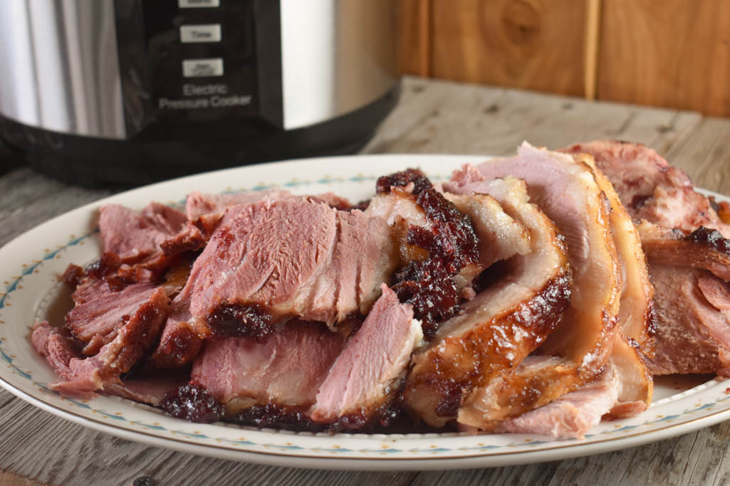 This Instant Pot Cranberry Glazed Ham recipe is so simple that it only has three ingredients, a ham, canned cranberry sauce and brown sugar.
