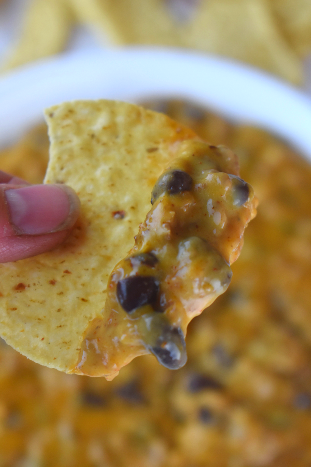 Velveeta Cheese Dip with Beans is the perfect game day recipe.  This cheesy Queso dip is taco flavored and full of ground beef and black beans. Serve with tortilla chips for the win!