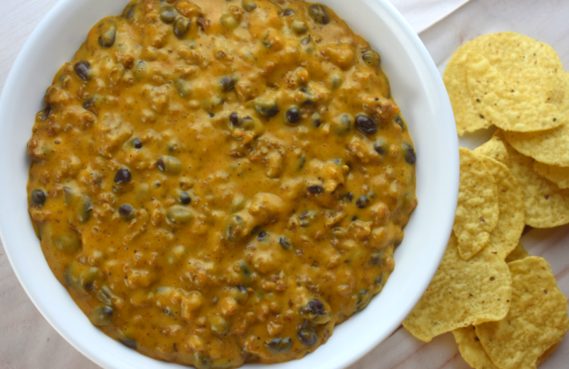 Velveeta Cheese Dip with Beans is the perfect game day recipe.  This cheesy Queso dip is taco flavored and full of ground beef and black beans. Serve with tortilla chips for the win!