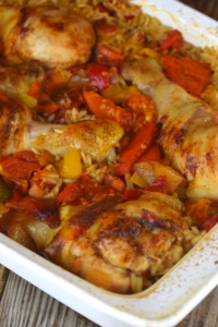 Spanish Chicken and Rice is a new spin on classic baked chicken and rice casserole.  This new and improved version contains peppers and tomatoes and is seasoned up with chili powder for some mild spice.  This one dish dinner will be a new favorite in your weeknight rotation.