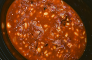 Crock Pot Baked Beans with Bacon is an easy recipe to throw together for your next party.  A combination of canned beans are bathed in a sweet brown sugar and ketchup based sauce that will compliment any entree.