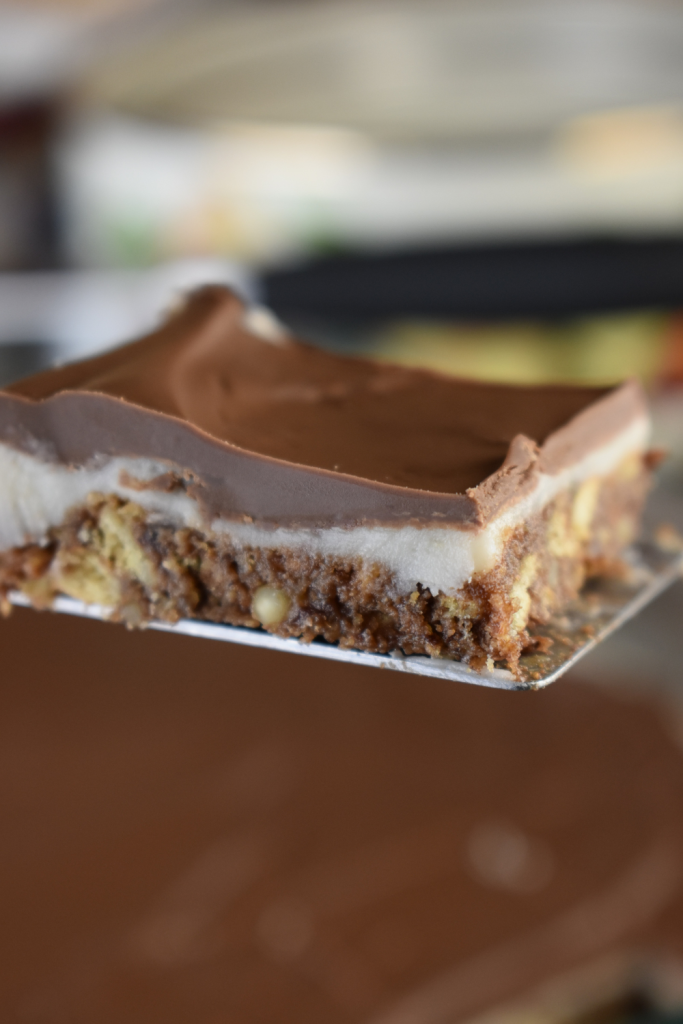 Grandma's Three Layer Chocolate Squares are a family favorite treat that are served every Christmas at my house. The triple layer cookie bar consists of a chocolate graham cracker crust, a vanilla cream center and a sweet Hershey's chocolate topping. 
