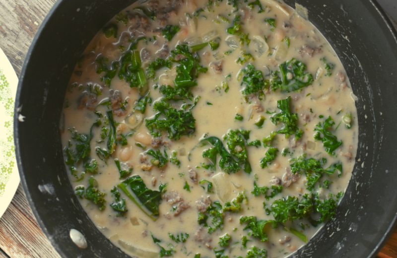 Tuscan Soup with Kale and Sausage is hearty soup that can be served up in thirty minutes. This recipe features pork sausage, cannellini beans, and kale with a creamy broth made with a combination of chicken broth and evaporated milk.