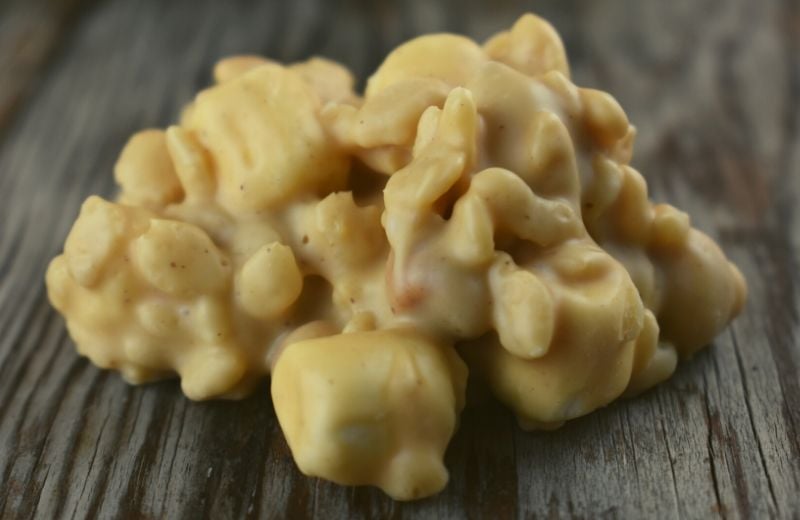 White Chocolate Peanut Clusters are a no bake peanut butter candy recipe that can be completed in less than 15 minutes.  The white chocolate peanut butter base coats a crunchy combination of peanuts and Rice Krispies that perfectly complements slightly melted mini marshmallows.  