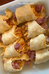 Ham and Cheese Crescent Rolls are the perfect way to use up leftover Holiday ham.  What's not to love about a buttery crescent roll stuffed with ham and cheese and smothered with a cheesy cream sauce?  