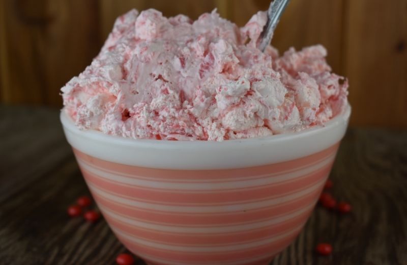 Cinnamon salad is a beautiful shade of pink making the perfect addition to a Christmas, Valentine's Day, bridal shower or baby shower.  This pink color comes from marinating Red Hots in crushed pineapple.  The color leaks from the candies into the pineapple into a dark shade of red. Then, Cool Whip and mini marshmallows are added to soften the red color into the color pink.