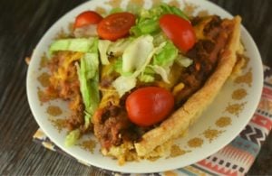 Deep Dish Taco Pie is stuffed full of ground beef, refried beans, cheese and crushed tortilla chips, all nestled in a pie crust.  Serve this easy taco pie at your next Taco Tuesday dinner.