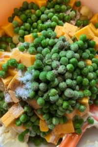 Tuna Pasta Salad is an Old Fashioned Macaroni Salad with Tuna that has frozen peas, albacore tuna and cheddar cheese cubes. It's simplicity can be deceiving since it packs a punch of flavor that is perfect for your summer dinner table. 