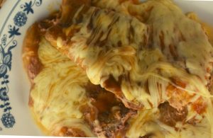 Slow Cooker Mexican Smothered Pork Chops is super easy to make.  This 4 Ingredient Crock Pot Pork Chop recipe includes enchilada sauce, cheddar cheese soup and shredded cheese.  Serve this up with refried beans and Spanish rice for the ultimate dinner.