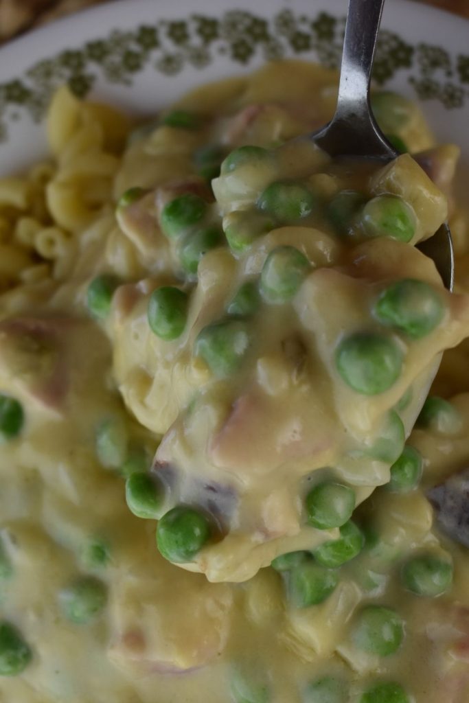 Creamy Pasta with Ham and Peas is so simple to make. Cubed ham and frozen peas are whipped up into a easy creamed mixture and served over cooked pasta or noodles. What's better? Use leftover ham in this ham and pea pasta recipe.
