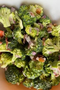 Old Fashioned Broccoli Salad has a perfectly sweet dressing. I promise you will love this broccoli salad with bacon,  raisins, sunflower seeds and cheese.  Sign up to bring it to your next family pitch-in. 