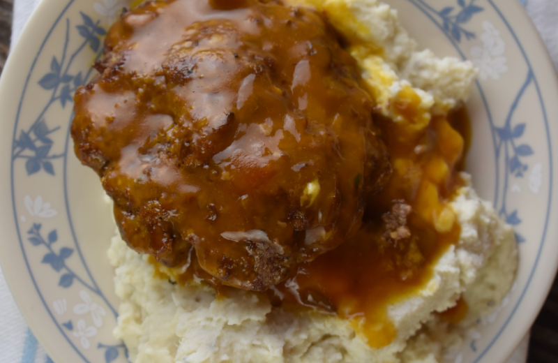 Salisbury steak is an easy to make ground beef patty baked covered by gravy. It is often served over mashed potatoes.