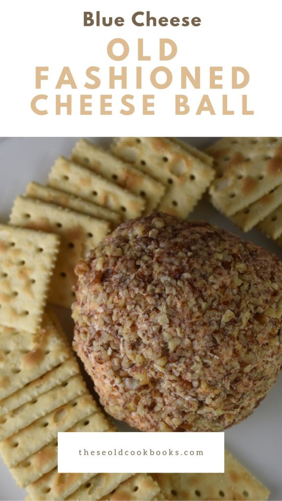 Cheese ball with blue cheese covered in nuts on a plate with crackers
