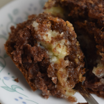 This German chocolate gooey layer cake is a vintage recipe made with cake mix, coconut, pecans, and a rich cream cheese filling.