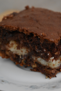 This German chocolate gooey layer cake is a vintage recipe made with cake mix, coconut, pecans, and a rich cream cheese filling.