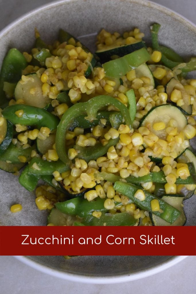 Plate with sweet corn, zucchini and green peppers sliced and sauteed to make zucchini and corn skillet